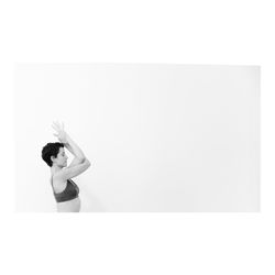 Side view of woman standing against white background