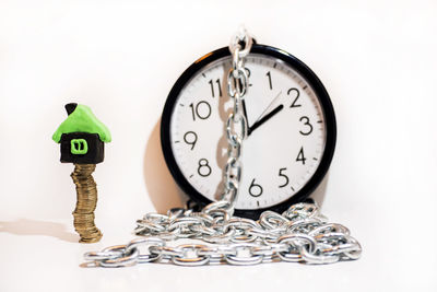 Close-up of clock on table against white background