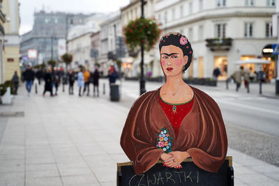 Portrait of woman standing on street in city