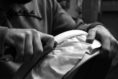 Hands of a man manufacturing a handmade bendir, musical instrument.