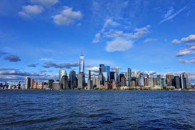 Modern buildings in city against cloudy sky