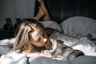 Mindfulness, being in the present moment, here and now. young woman play with kitten at home in