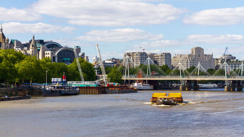 London a tug boat pulling fright on the thames in london in front of hungerford bridge