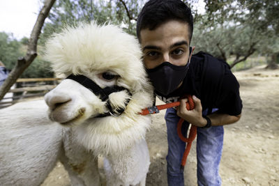 Portrait of young man and his alpaca