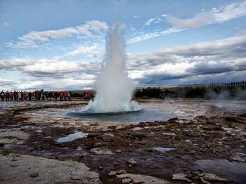 Panoramic view of people on shore against sky