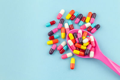 Multi colored capsule over blue background