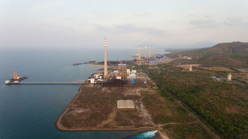 Aerial view power station on the sea coast, jawa island. larger industrial power plant in indonesia.
