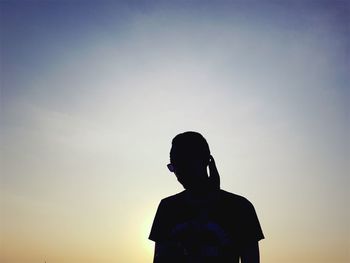 Low angle view of silhouette woman standing against sky