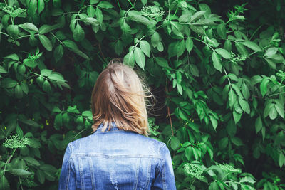 Rear view of woman standing by plants