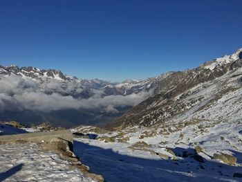 Scenic view of snow mountains against blue sky