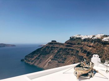 Buildings on mountain by sea against sky