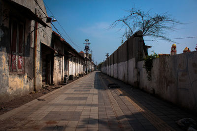 Footpath amidst buildings against sky