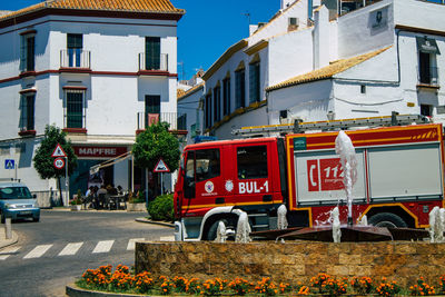 Street by buildings against sky in city