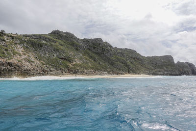 Scenic view of sea and mountains against sky