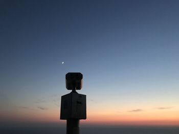 Low angle view of illuminated light against sky at sunset