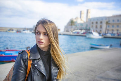 Beautiful woman standing against city in background