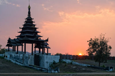 Traditional building against sky during sunset