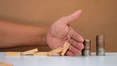Cropped image of hand holding coins on table