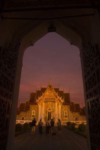 People walking towards temple against the sky