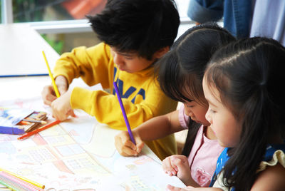Children with teacher drawing in classroom