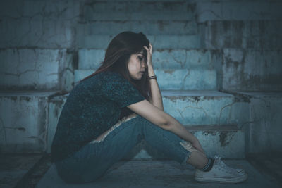 Woman sitting against wall