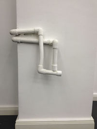 Close-up of pipes against white wall