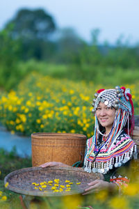 Close-up of woman with yellow flowers in field