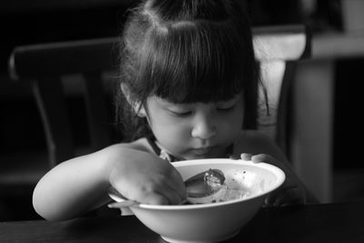 Girl by food in bowl on table