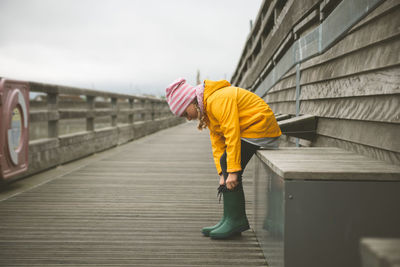 Side view of woman walking on footpath