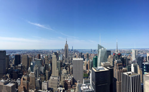 Manhattan against blue sky on sunny day