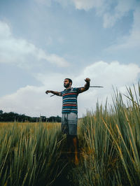 Rear view of woman standing on field against sky