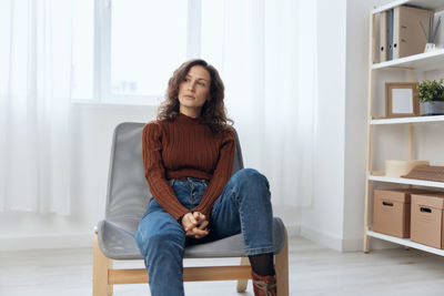 Young woman sitting on sofa at home