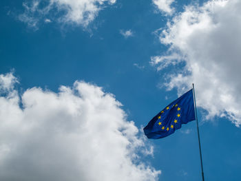 Low angle view of european union flag cloudy sky