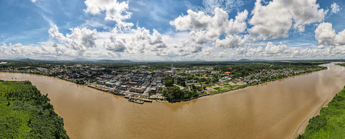 Panoramic shot of city buildings and river against sky