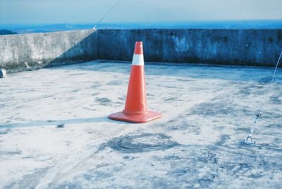 Close-up of arrow sign on road against sky