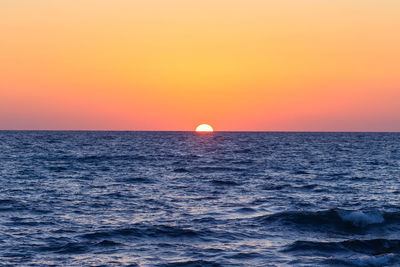 Scenic view of sea against orange sky