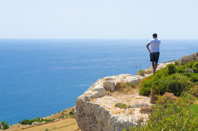 Rear view of man standing by the mediterranean sea 