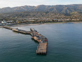 High angle view of sea against mountain with pier