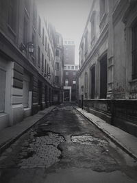 Road amidst buildings in city against sky