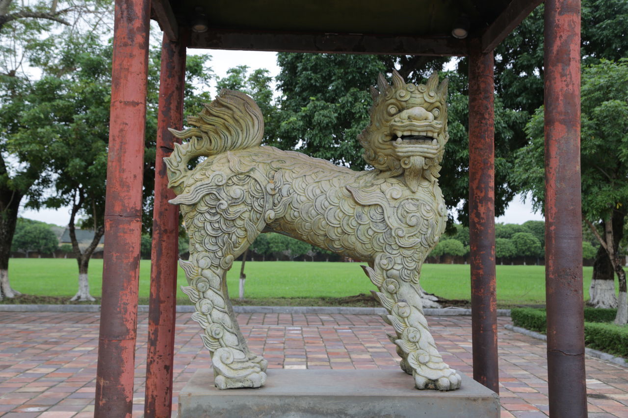 STATUE IN PARK AGAINST TEMPLE