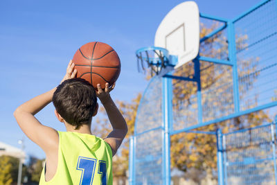 Boy playing basketball on court