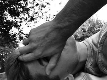 Close-up of couple hands on tree