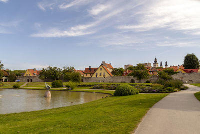 Scenic view of river by buildings against sky