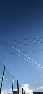 Low angle view of vapor trail against blue sky