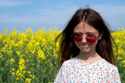 Portrait of beautiful woman wearing sunglasses on field