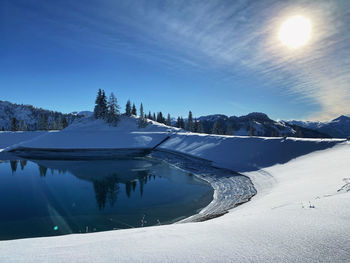 Scenic view of frozen lake against sky during winter