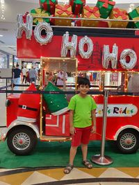 Full length portrait of smiling boy standing on railroad track