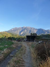 Scenic view of landscape and mountains against blue sky