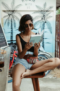 Full length of woman sitting outdoors