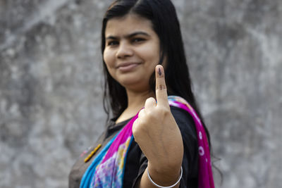 Selective focus on ink-marked finger of an indian woman with smiling face